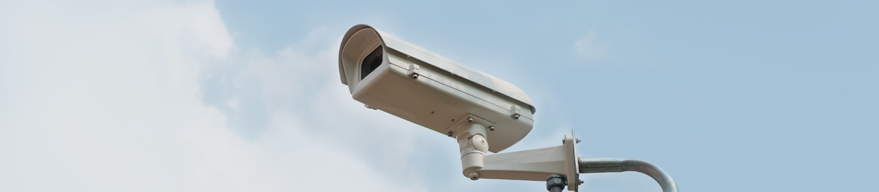 photo of a security camera against blue sky
