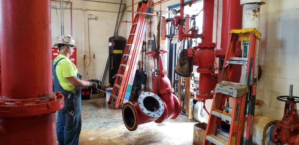Worker inspecting large industrial pipes