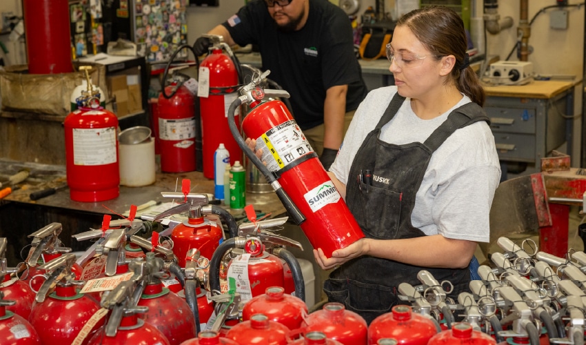 Summit employees inspecting fire extinguishers