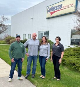 the team standing outside of the office building