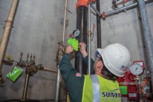 Worker inspecting industrial piping system