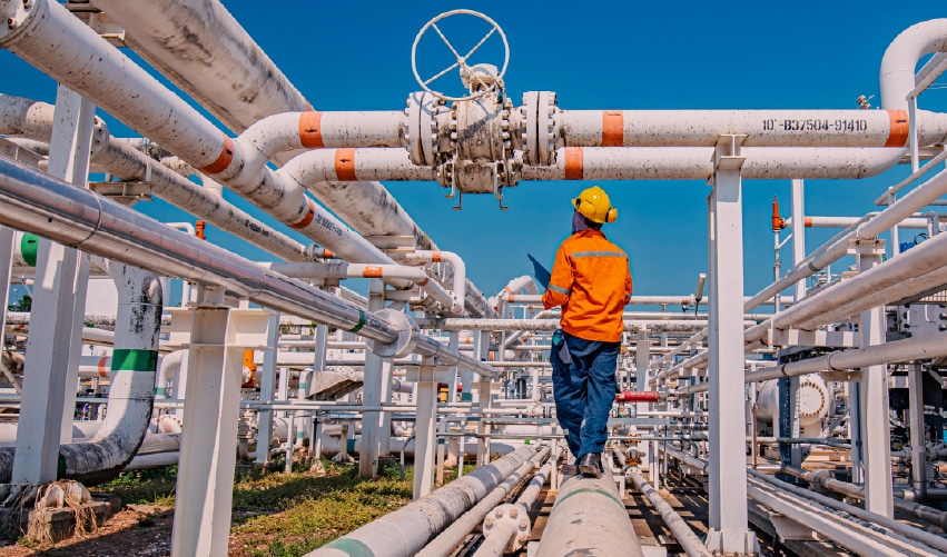 Worker inspecting industrial pipeline system