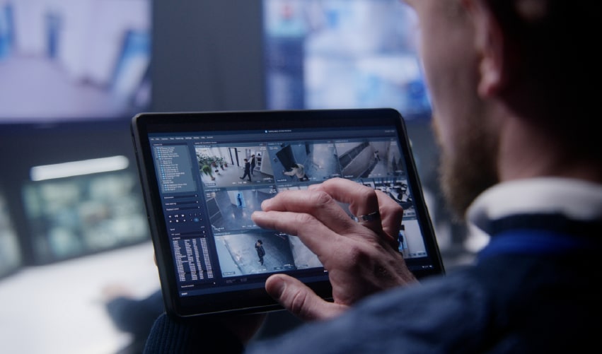 Person monitoring security cameras on a tablet