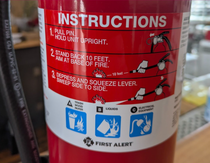 Close up of fire extinguisher manufacturer’s label with 3-step instructions for use, ABC fire classification, and First Alert logo