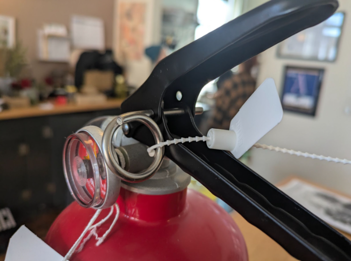 Close up of plastic tamper seal on fire extinguisher handle
