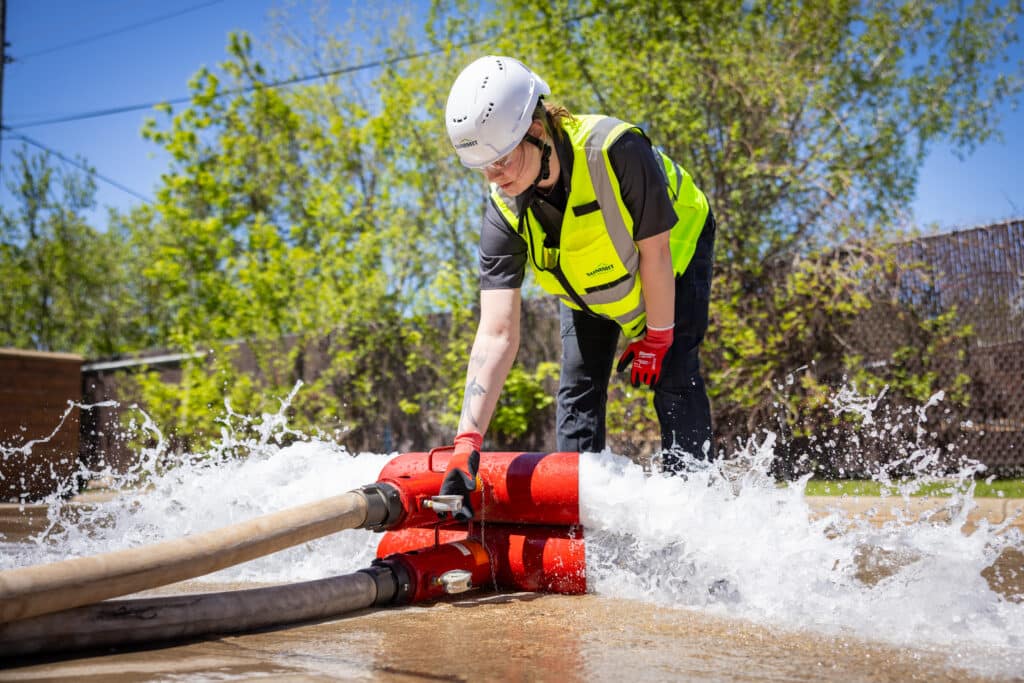 Person managing water flow with hoses