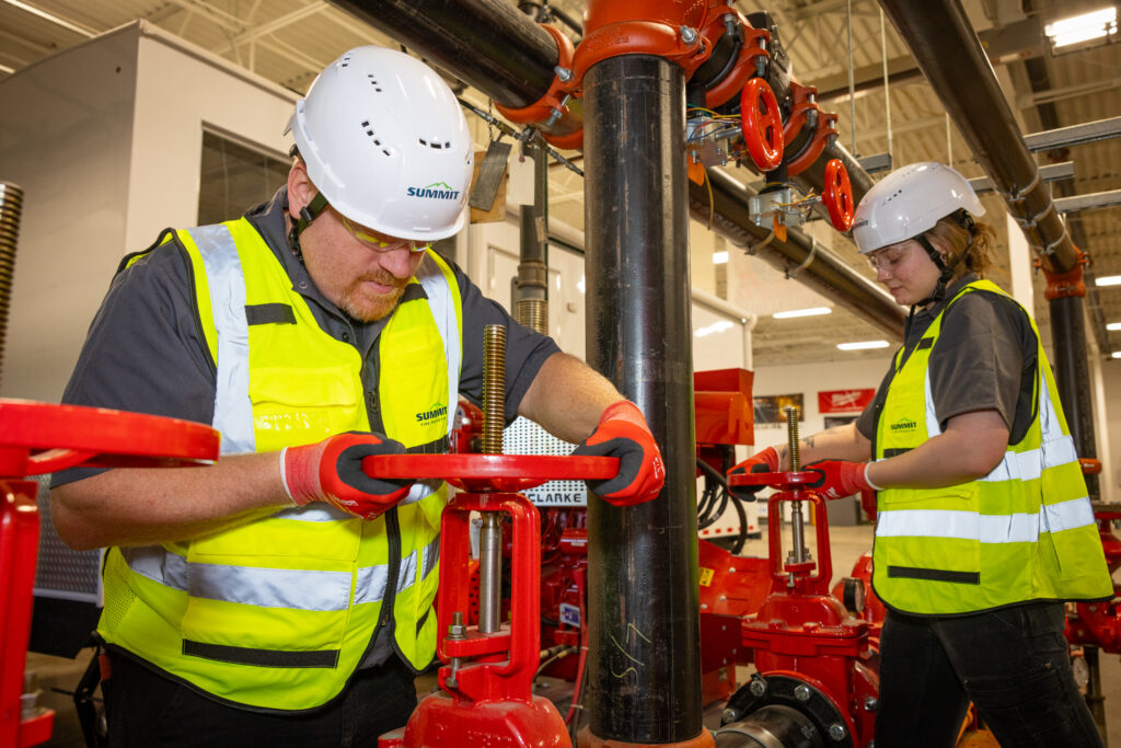 Workers in safety gear operating valves