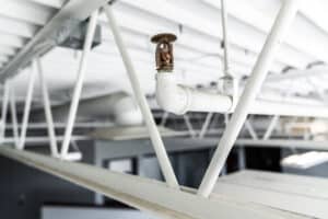 A sprinkler head on the ceiling of a commercial building